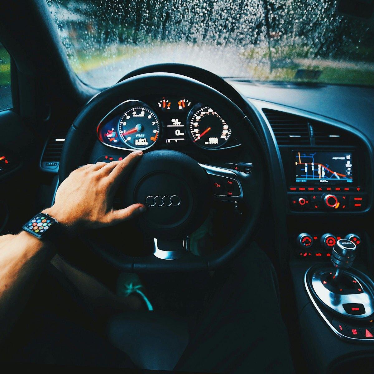 Driver with a hand on the steering wheel